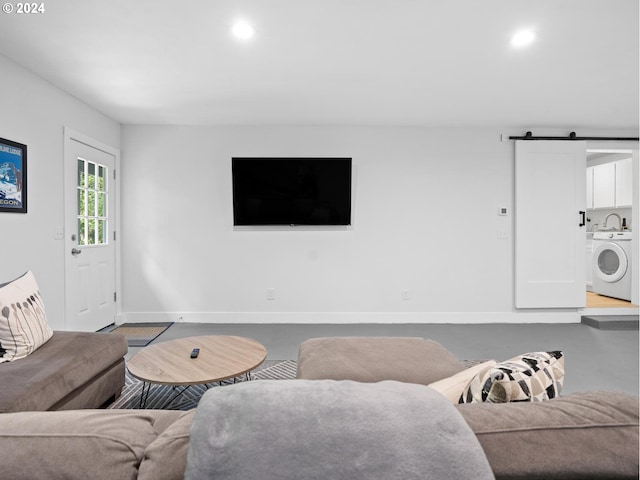 living room featuring a barn door and separate washer and dryer