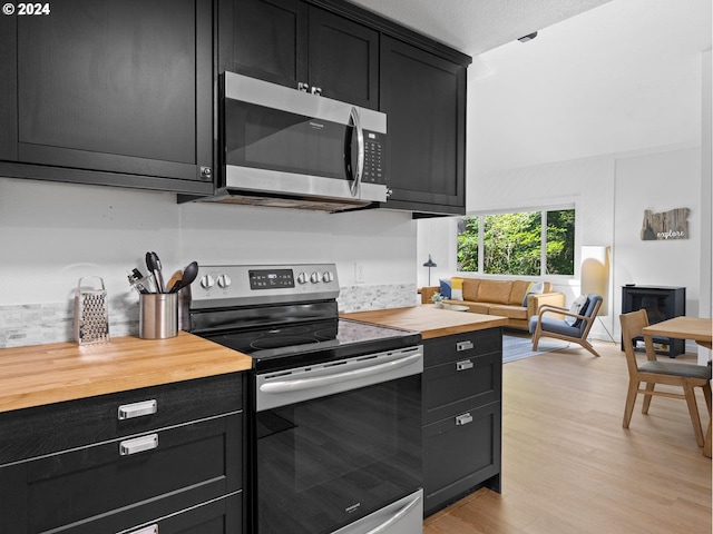 kitchen with appliances with stainless steel finishes, light hardwood / wood-style flooring, and butcher block counters