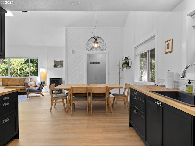 kitchen with a wealth of natural light, sink, decorative light fixtures, and light wood-type flooring