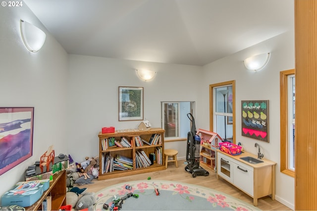 playroom featuring sink and light hardwood / wood-style floors