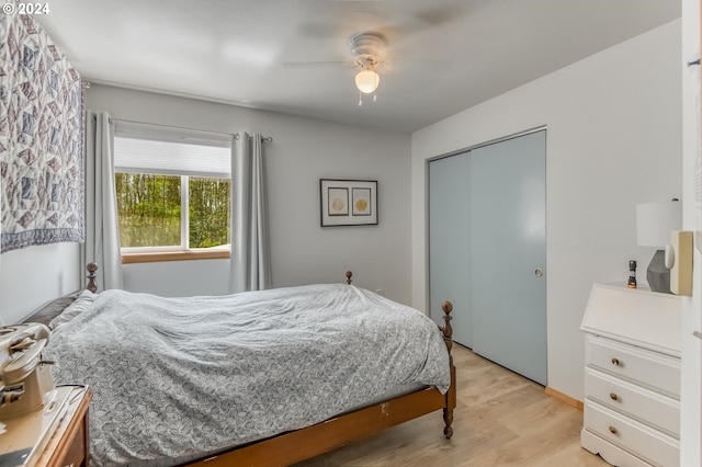 bedroom with ceiling fan, light hardwood / wood-style floors, and a closet