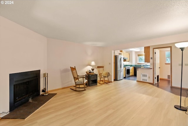 living area featuring light hardwood / wood-style flooring and a textured ceiling