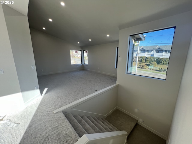 spare room with carpet flooring and lofted ceiling