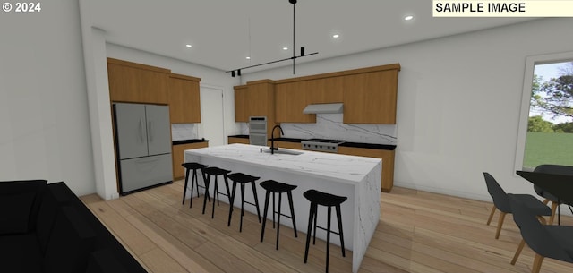 kitchen featuring an island with sink, tasteful backsplash, pendant lighting, and white fridge