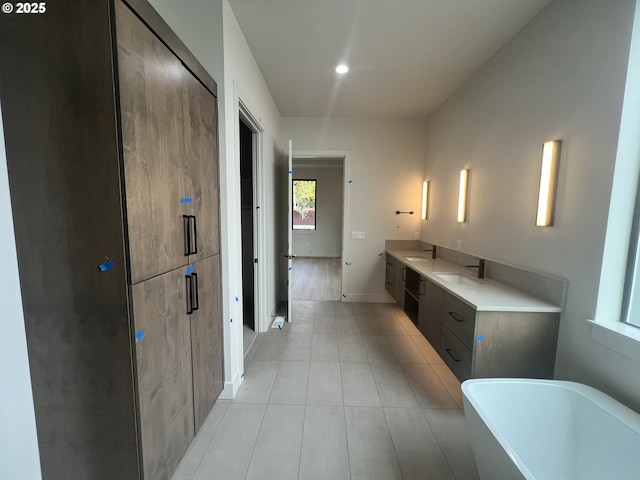 bathroom featuring tile patterned floors, vanity, and a washtub