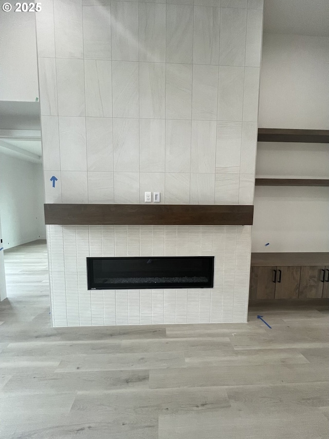 room details featuring a tile fireplace and hardwood / wood-style floors