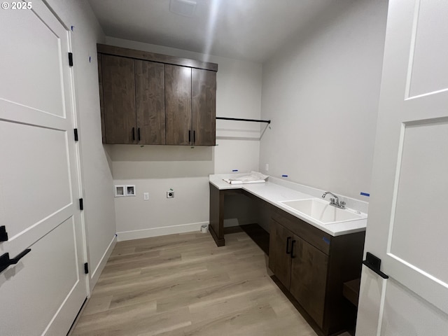 clothes washing area featuring sink, cabinets, light wood-type flooring, electric dryer hookup, and washer hookup