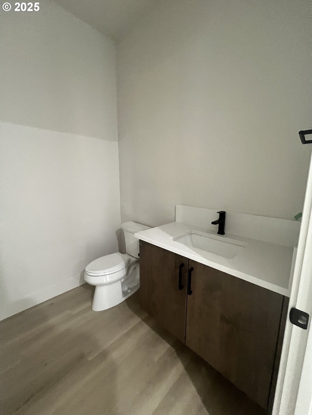 bathroom featuring vanity, hardwood / wood-style floors, and toilet