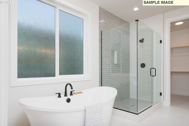 bathroom with independent shower and bath and tile patterned flooring