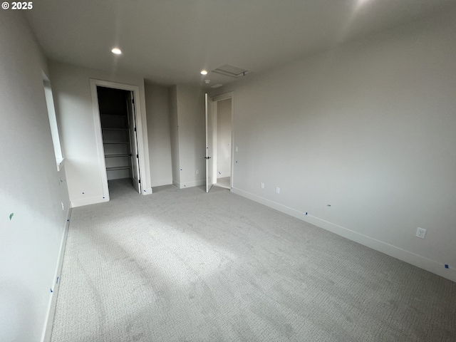 unfurnished bedroom with a walk in closet, carpet floors, and a closet