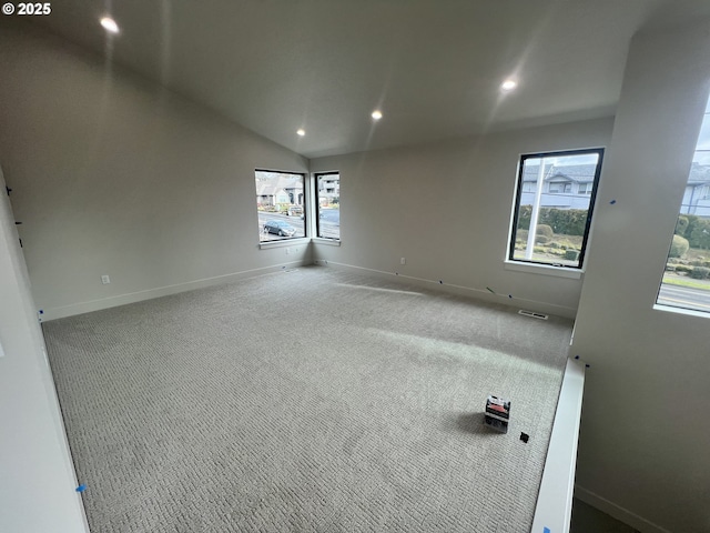 carpeted spare room featuring lofted ceiling