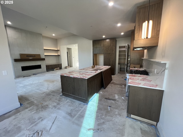 kitchen with dark brown cabinets, pendant lighting, and stainless steel gas range