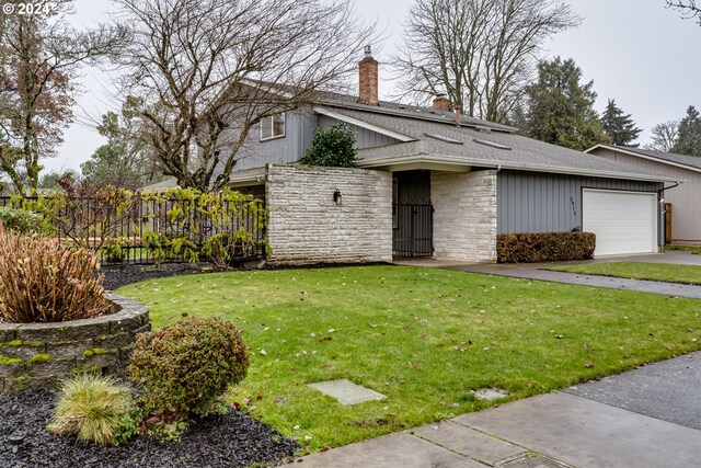 view of front of property featuring a garage and a front lawn