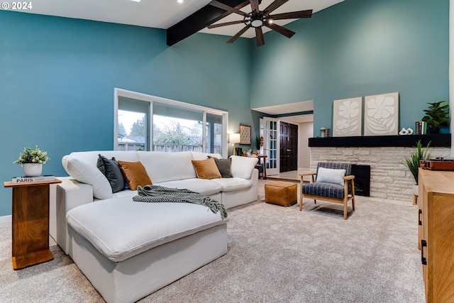 living room with a ceiling fan, a high ceiling, a fireplace, beamed ceiling, and carpet flooring