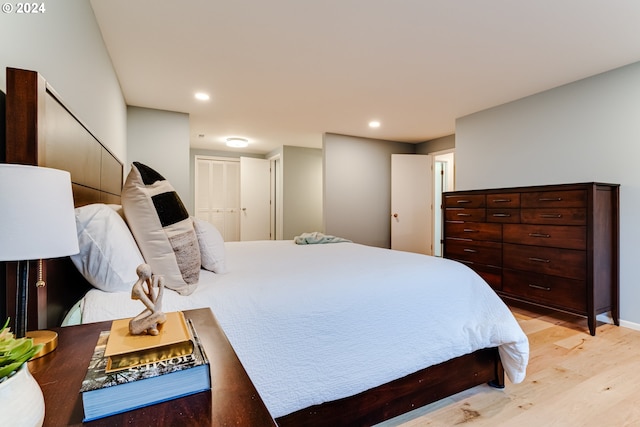 bedroom with recessed lighting, light wood-style floors, and a closet