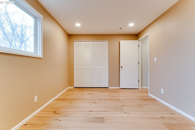 unfurnished bedroom with recessed lighting, baseboards, and light wood-type flooring