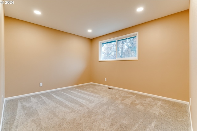 carpeted empty room featuring visible vents, recessed lighting, and baseboards