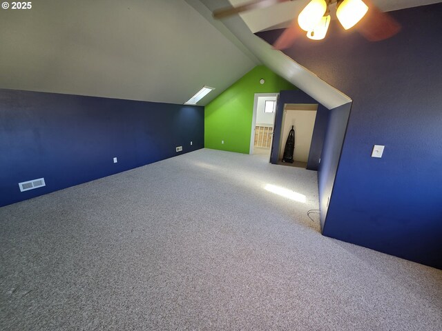 additional living space featuring carpet and lofted ceiling with skylight