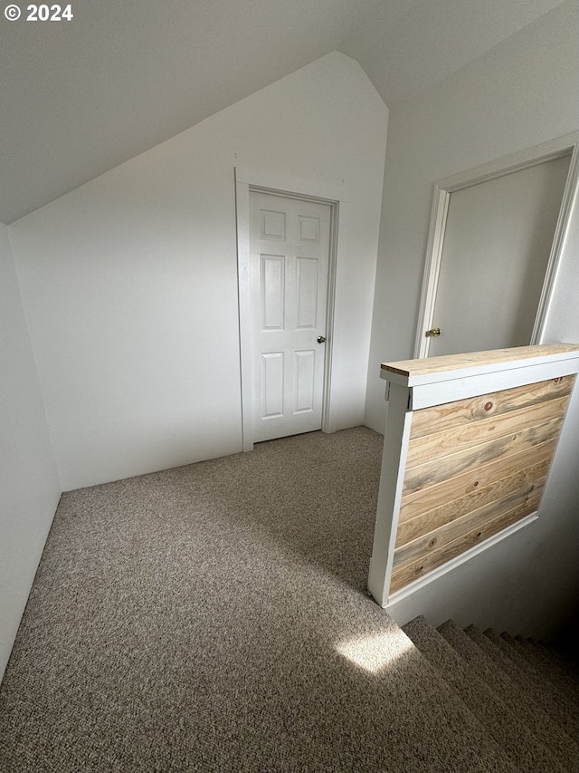 interior space with carpet floors and vaulted ceiling