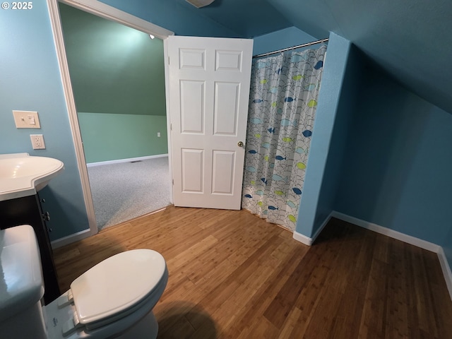 full bath featuring lofted ceiling, a shower with shower curtain, toilet, wood finished floors, and baseboards