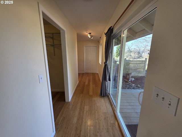 hall featuring light wood finished floors and baseboards