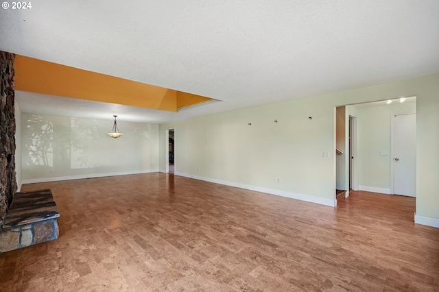 unfurnished living room with a textured ceiling and a tray ceiling