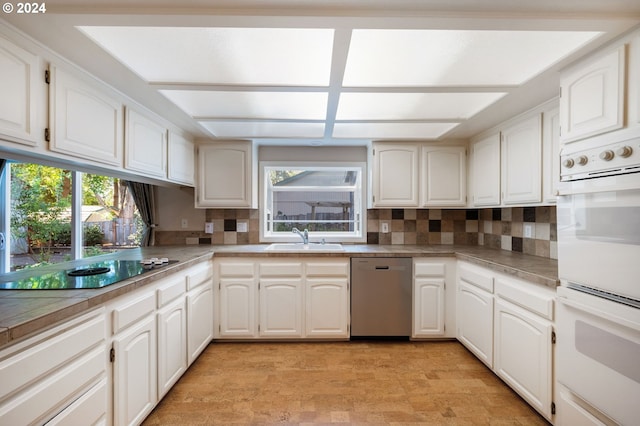 kitchen with white cabinetry, black electric cooktop, dishwasher, and white double oven