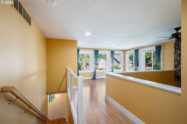 hallway featuring a textured ceiling and hardwood / wood-style flooring