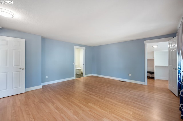 spare room featuring baseboards, visible vents, and light wood-style floors