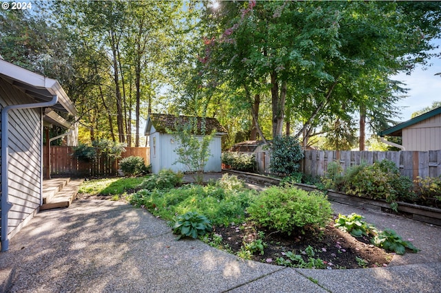 view of yard with a storage shed, a fenced backyard, a patio, and an outdoor structure