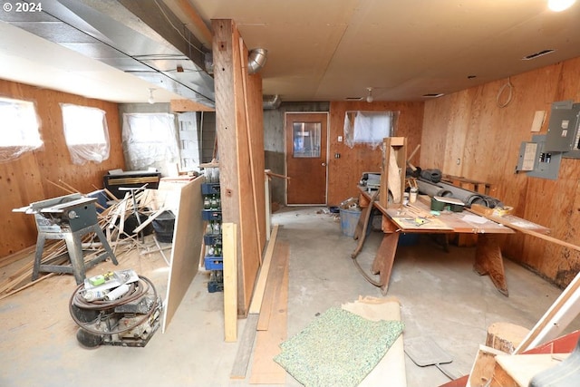 basement featuring a workshop area and wooden walls