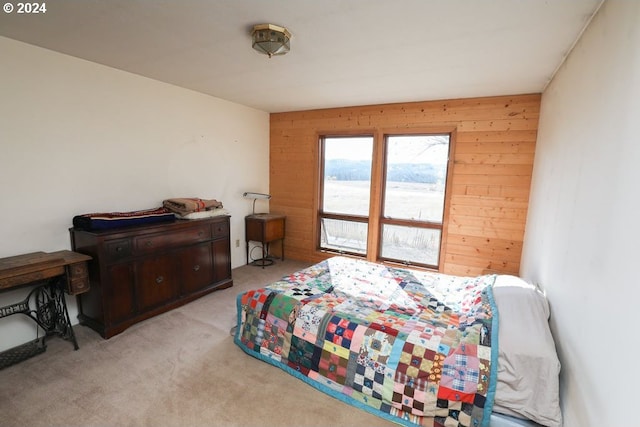 bedroom with light colored carpet and wooden walls