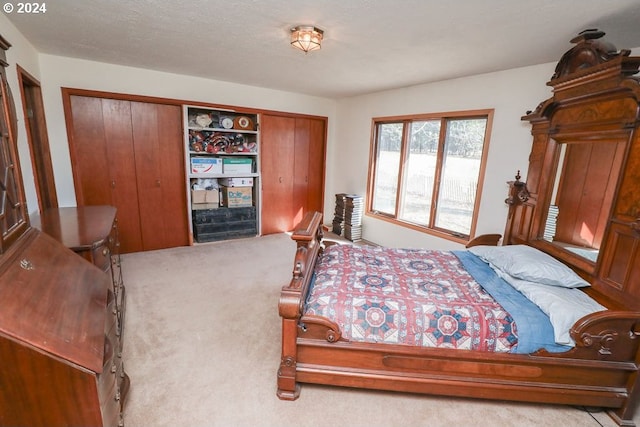 carpeted bedroom featuring a textured ceiling and a closet