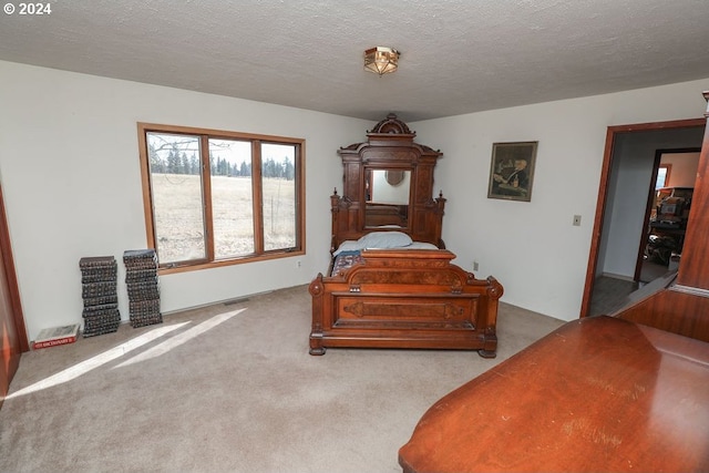 bedroom with light carpet and a textured ceiling