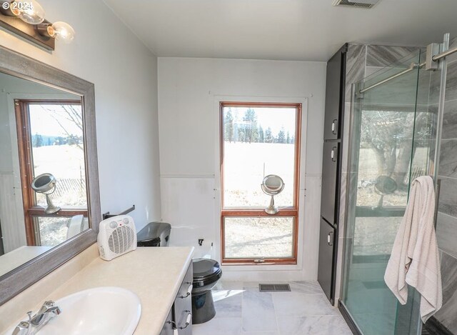 bathroom with an enclosed shower, plenty of natural light, toilet, and vanity