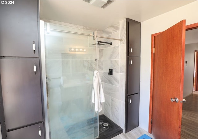 bathroom featuring hardwood / wood-style flooring and a shower with door