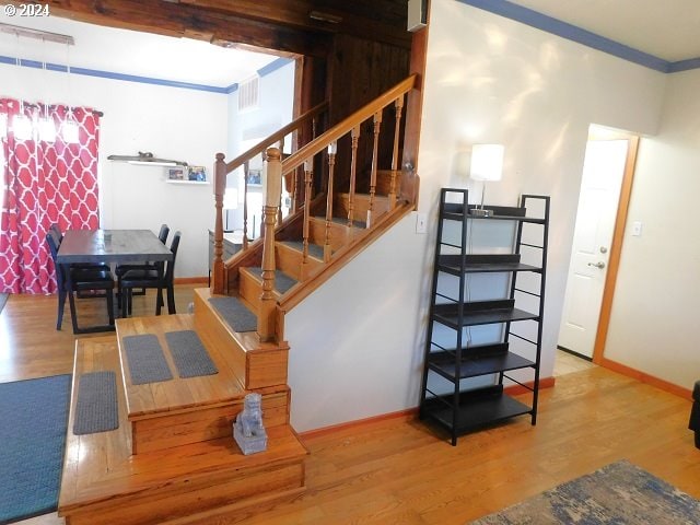 staircase featuring hardwood / wood-style floors and crown molding