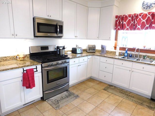 kitchen featuring white cabinets, appliances with stainless steel finishes, and sink