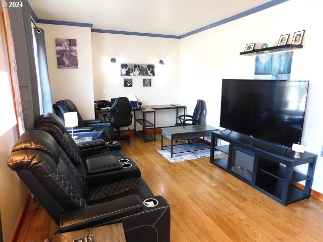 living room with wood-type flooring and ornamental molding