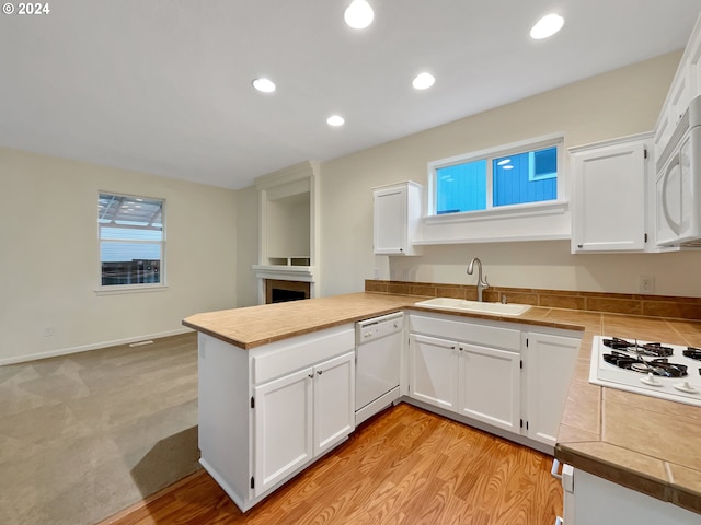 kitchen with kitchen peninsula, white cabinetry, white appliances, and sink