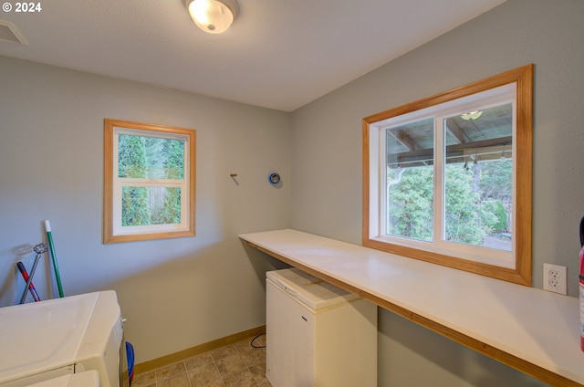 laundry area featuring light tile patterned flooring, a healthy amount of sunlight, and separate washer and dryer