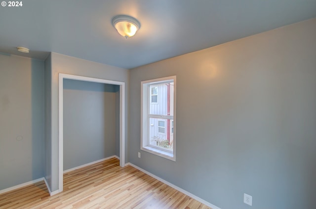 unfurnished bedroom featuring light hardwood / wood-style flooring and a closet