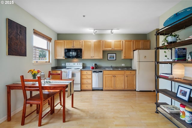 1134 SW Jefferson St Unit 506, Portland, OR 97201 - kitchen featuring white appliances, light wood-style floors, dark countertops, and baseboards