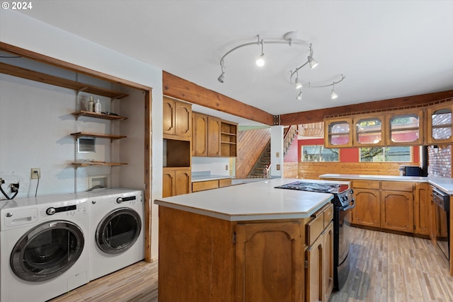 clothes washing area featuring washing machine and dryer and light hardwood / wood-style flooring