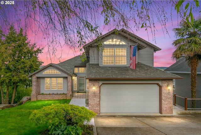 view of front of house with a garage, a yard, brick siding, and driveway