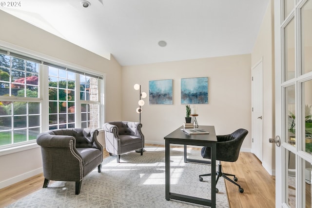 office area featuring lofted ceiling, french doors, light wood-type flooring, and baseboards