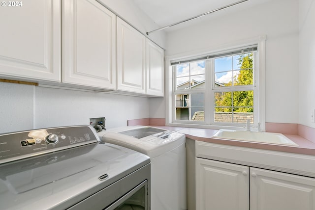 laundry area featuring a sink, cabinet space, and washer and dryer