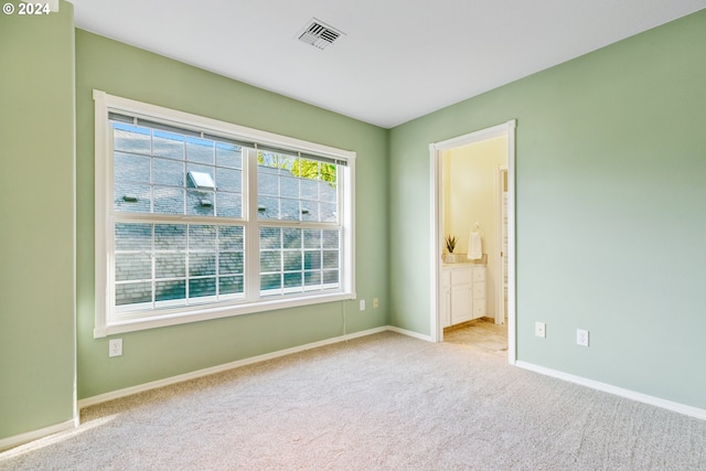 carpeted empty room with visible vents and baseboards