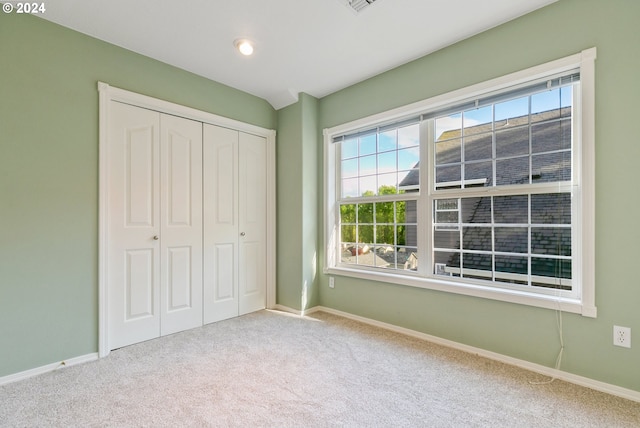 unfurnished bedroom with a closet, carpet flooring, and baseboards