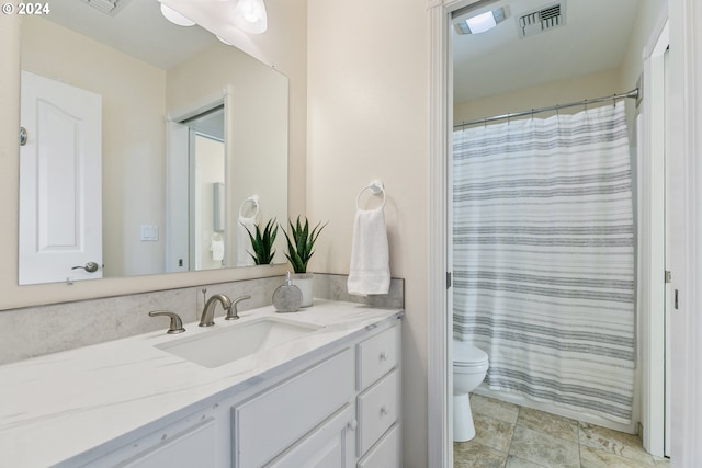 full bathroom featuring toilet, a shower with shower curtain, vanity, and visible vents